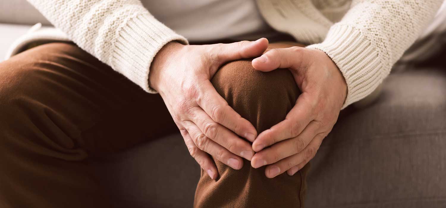 Ältere Dame hält sich den Finger ans Ohr, als ob sie schlecht hören würde.