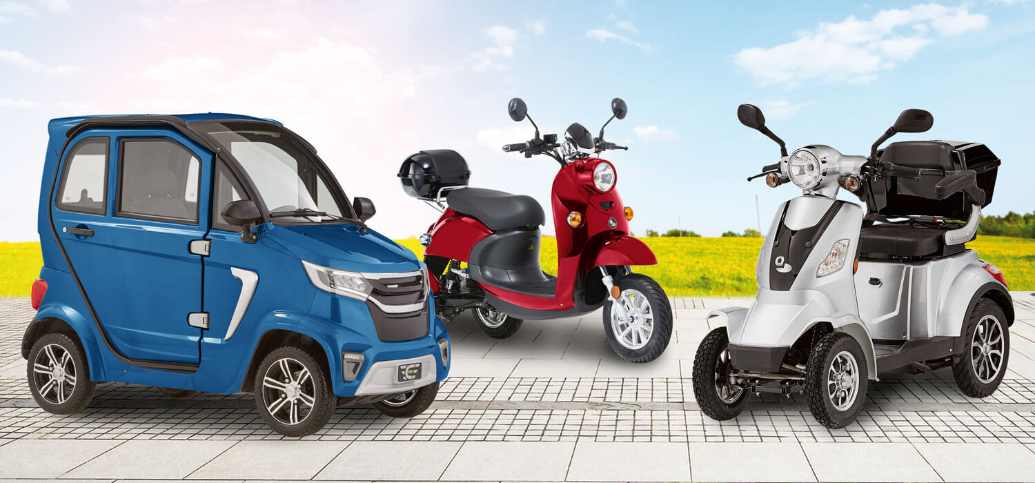 Es sind verschiedene Arten von Elektromobilen abgebildet: Ein blaues Kabinenfahrzeug, daneben ein rotes Dreirad-Elektromobil und ein silbernes Vierrad-Elektromobil.
