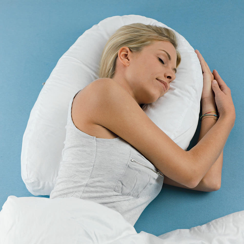 Frau liegt auf einem speziellen Seitenschläferkissen, das den Körper im Schlaf entlastet.